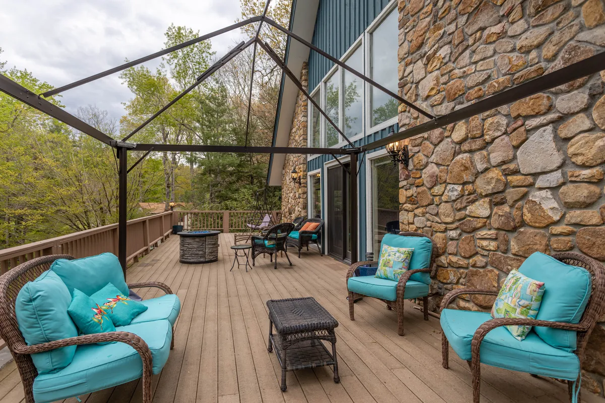 An inviting outdoor seating area with a stone wall, decorative pillows, and a fire pit, perfect for relaxing or socializing amid nature. The scene suggests peaceful evenings spent fireside and opportunities for birdwatching, connecting both to the spirit of relaxation and outdoor enjoyment.